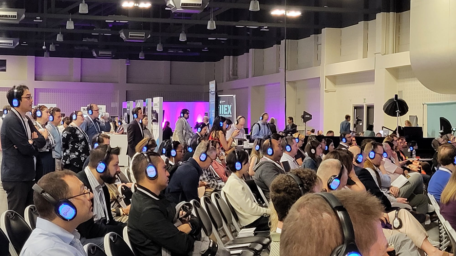 IIEX conference attendees with headsets turned blue